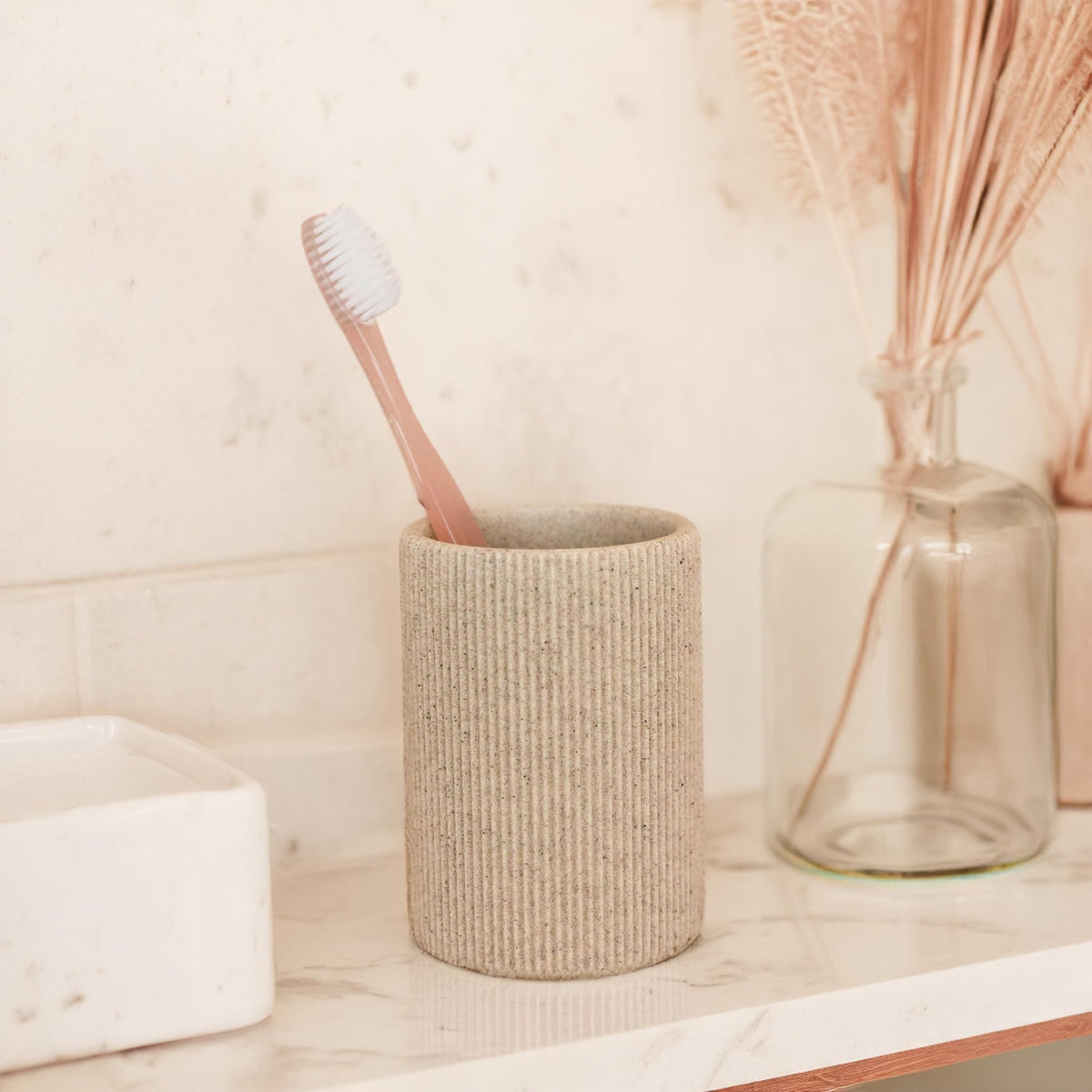 Lunestella sand-beige detail complements soap dispensers for a cohesive bath decor set.