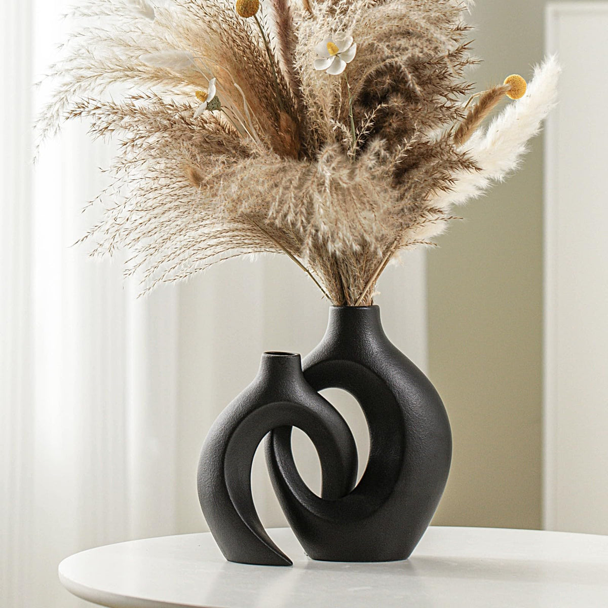 Lvases Snuggle Hollow tall vase with matte off-black finish for fresh flower centerpieces.