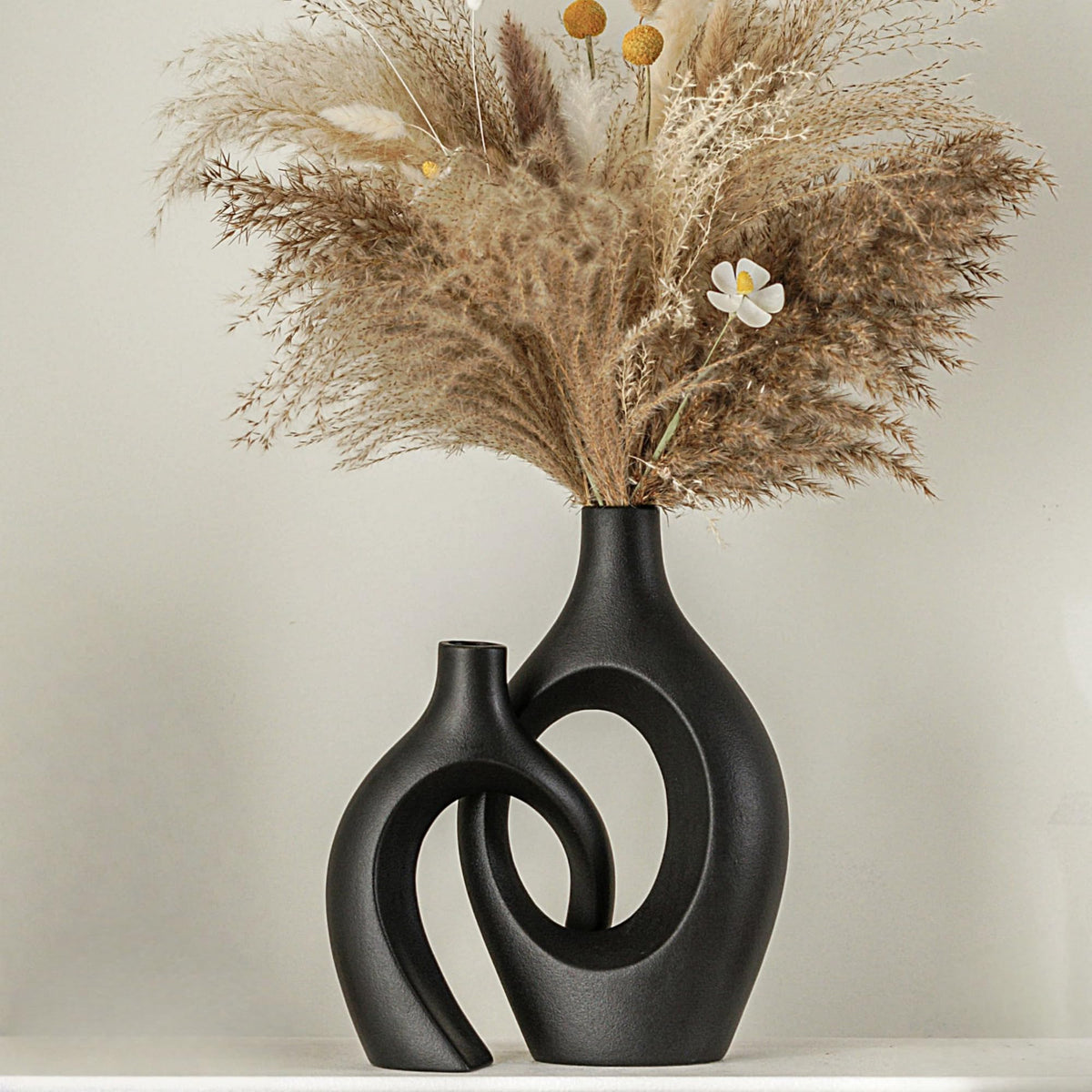 Lvases Snuggle Hollow tall vase in matte black for elegant centerpiece arrangements.