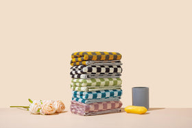 Madi-Cadi hand towels purple checkered design suitable for hotel-style guest rooms.