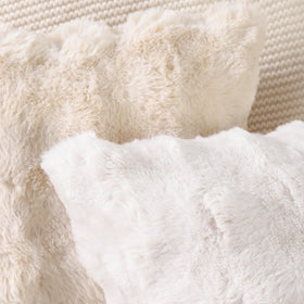 MADIZZ cream cushion cover shown on a cozy sofa in a living room.