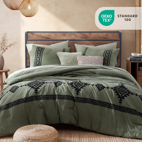 Close-up of MaiRêve embroidery on olive green comforter showing 3D pattern