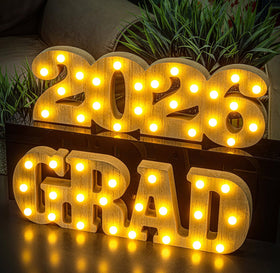 MEADIN Grad 2026 LED letters glow on a graduation table centerpiece