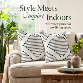 Mecatny cream base pillow cover with black tassels enhances sofa styling.
