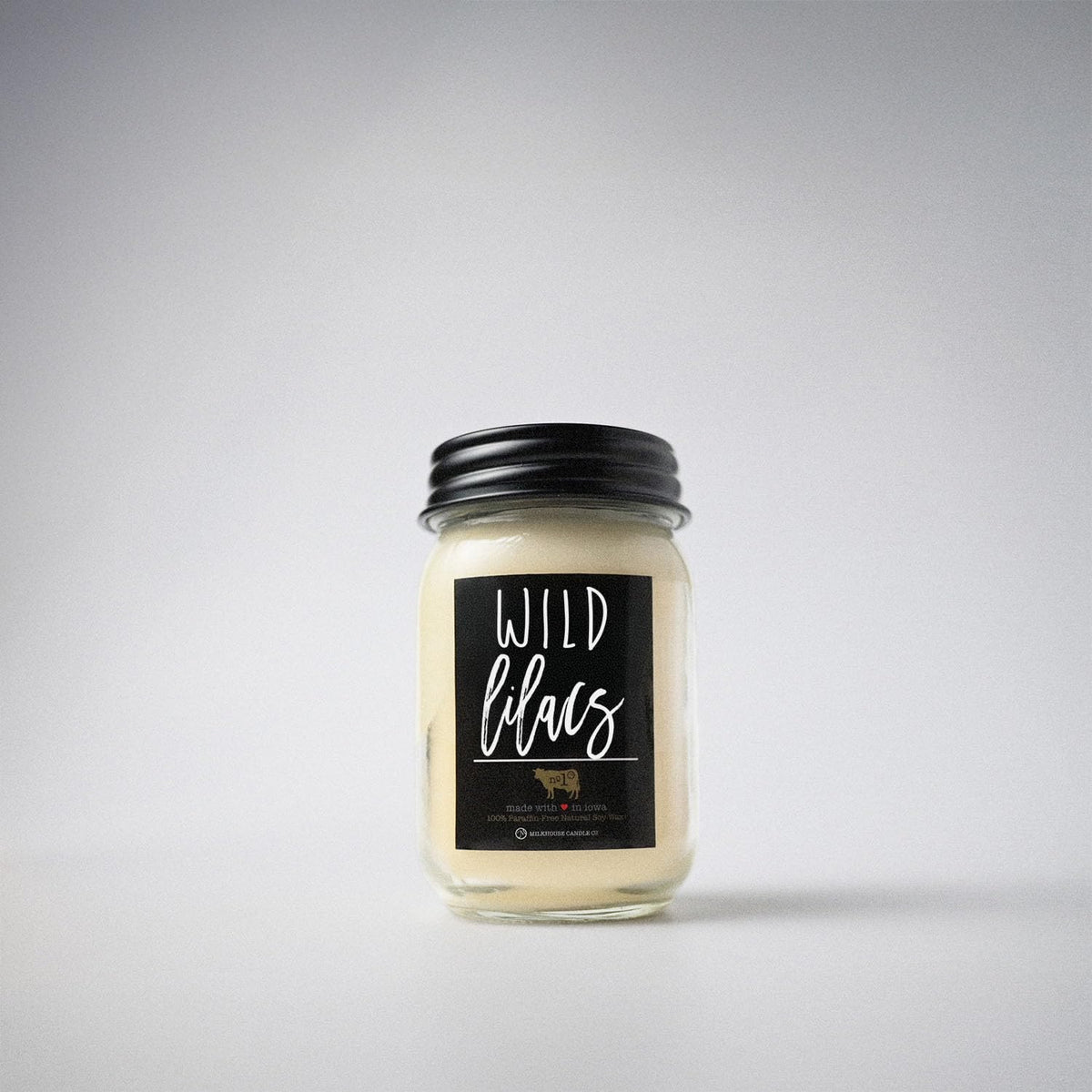 Milkhouse Wild Lilacs candle on a shelf creating a cozy spring atmosphere.