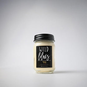 Milkhouse Wild Lilacs candle on a shelf creating a cozy spring atmosphere.