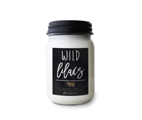 Milkhouse Wild Lilacs candle in a 13 oz jar with lid, inviting floral ambiance.