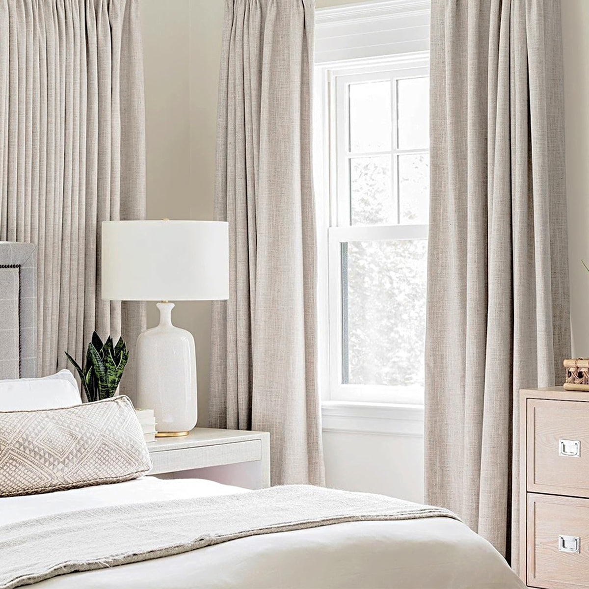 Close-up of MIULEE grommets on ivory blackout curtains for easy installation.