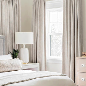Close-up of MIULEE grommets on ivory blackout curtains for easy installation.