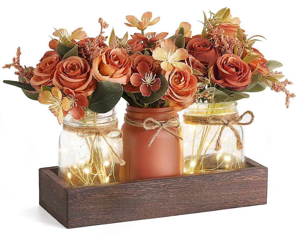 Mkono mason jar lights centerpiece on wood tray for rustic dining ambiance.