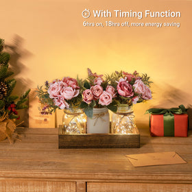 Mkono three jars with artificial flowers illuminated by warm string lights