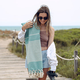 MOMOMUS beach blanket sea green yoga setup for stretches.