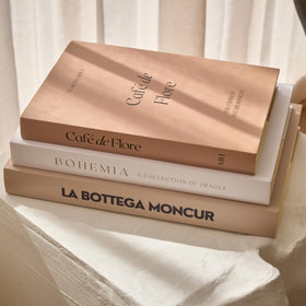 Moncur Home faux books with beige and white covers elevate coffee table styling.