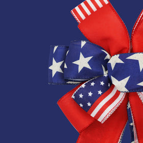 Montekin tree-topper patriotic bow enhances front door display in blue.