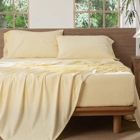 Butter yellow MooMee bedding styled in a cozy bedroom scene.