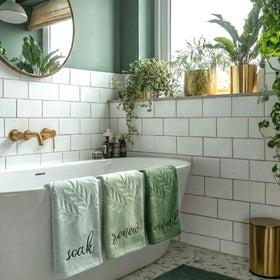Moukeren bathroom decor display with sage towels supporting a serene space.