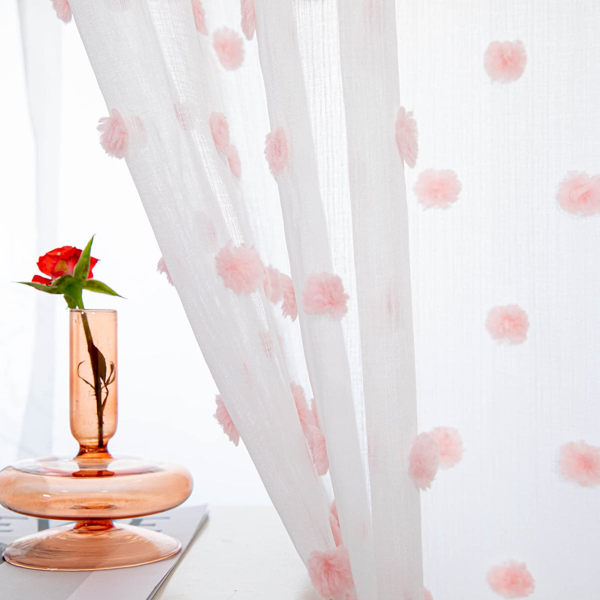 MYSKY HOME pom pom sheer pink curtains add soft light and whimsy to a room.