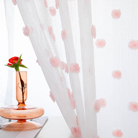 MYSKY HOME pom pom sheer pink curtains add soft light and whimsy to a room.