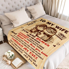NAIREG anniversary gift blanket laid on bed showing premium material.