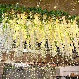 Realistic silk petals on a dense wisteria garland for decor.