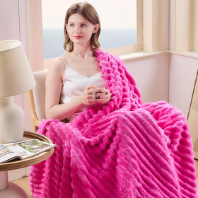 Close-up of NEWCOSPLAY hot pink ribbed throw texture showing ultra-soft microfiber