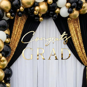 Novabright graduation decor attracts attention with gold lettering and shine.