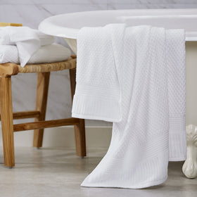 Towels draped in a bright bathroom to convey clean luxury.