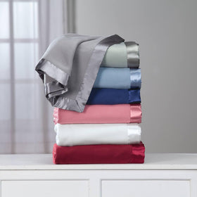 OakRidge satin fleece blanket folded on bed demonstrates versatile size options.