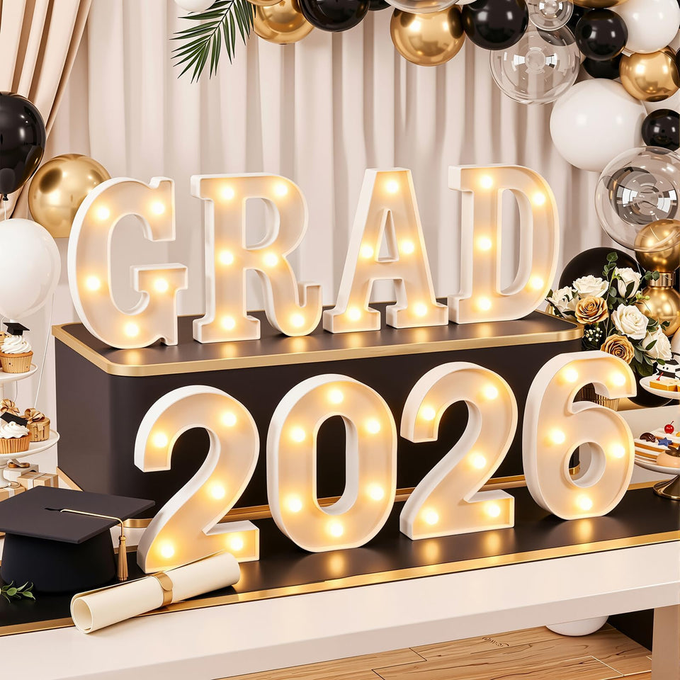 OLANRUN GRAD 2026 letters on table glow warmly for graduation photos