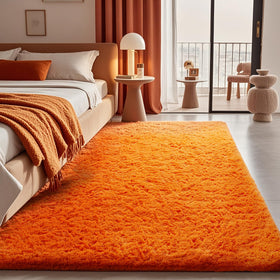 Ophanie Orange Fall Rug in a cozy bedroom setting with plush softness.