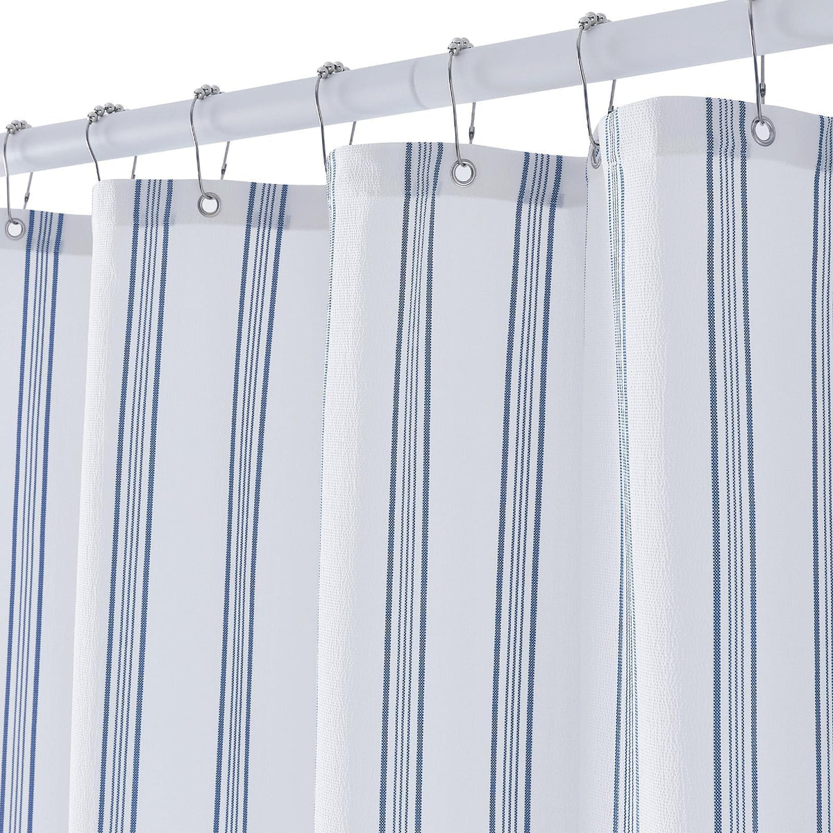 ORTIGIA blue and white striped shower curtain enhances bathroom organization and style.