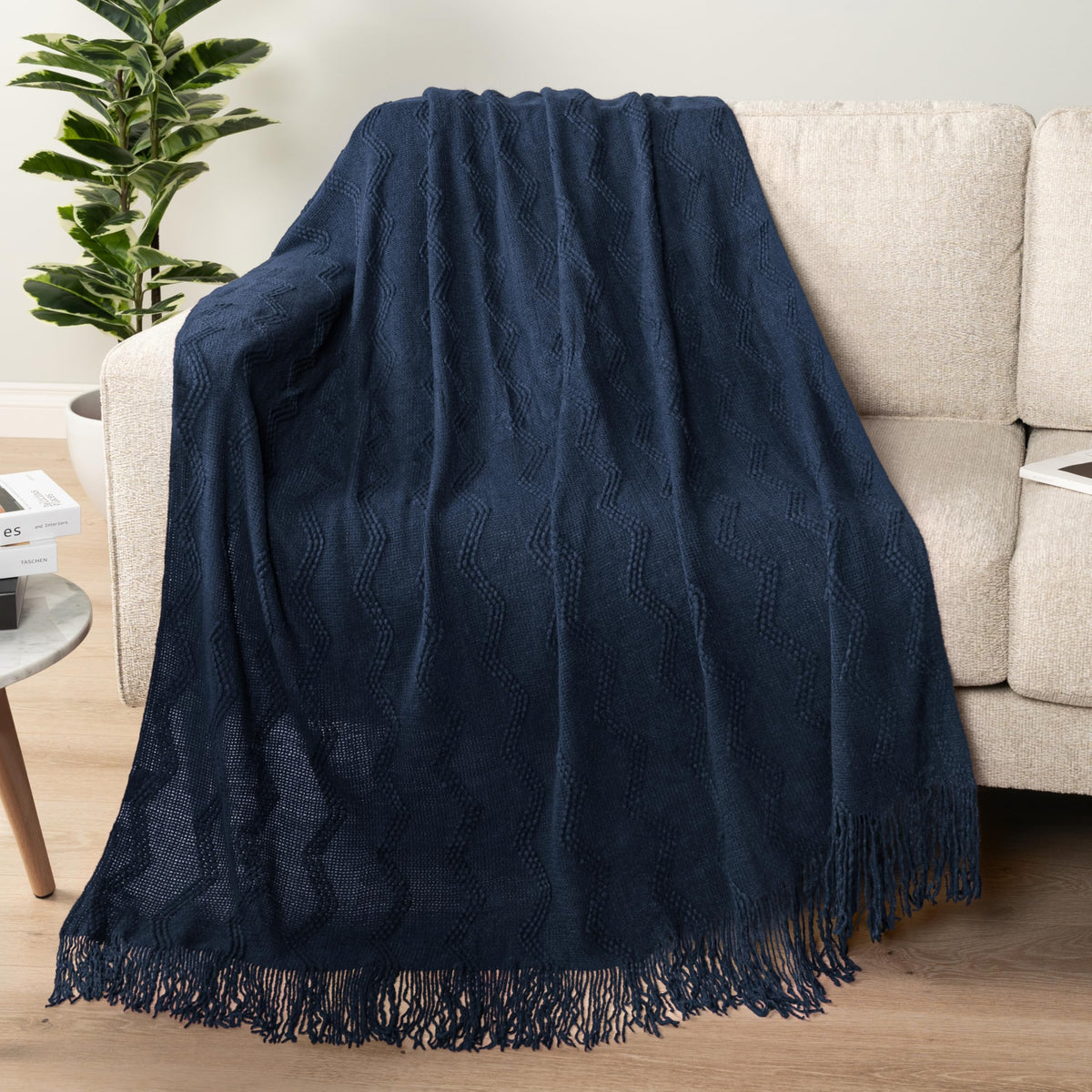 PAVILIA navy blue knit throw on sofa showing textured zigzag pattern.
