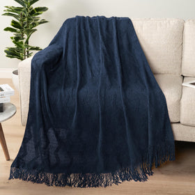 PAVILIA navy blue knit throw on sofa showing textured zigzag pattern.
