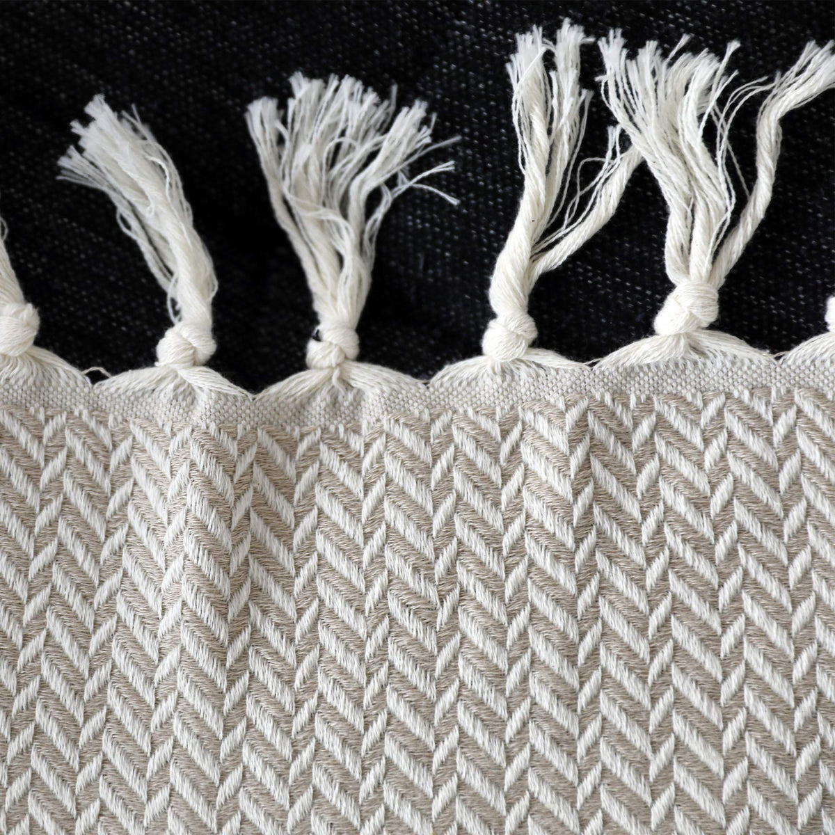 Peshtemania rolled blanket on a sofa for warm, chic living room style.