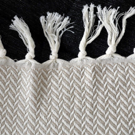 Peshtemania rolled blanket on a sofa for warm, chic living room style.