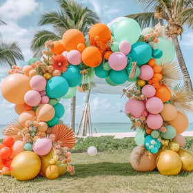 Pinbra pastel balloon arch with coral pink and teal for tropical decor.