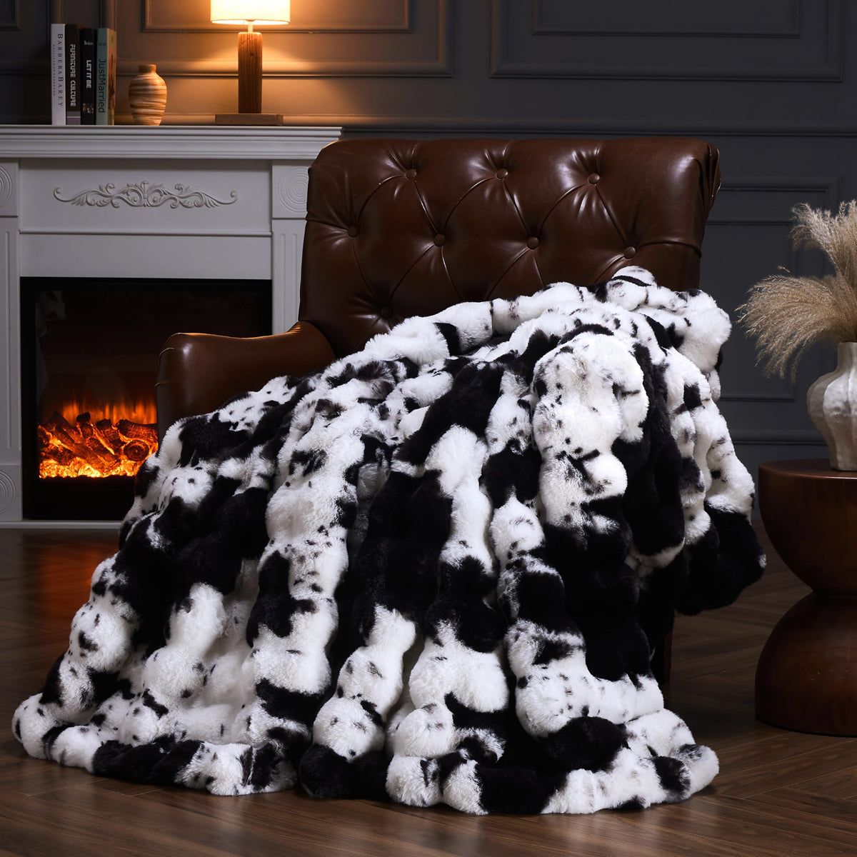 PLUUSHUU cow-print blanket on sofa adds cozy warmth and style.