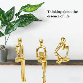 Prettidecor gold thinker trio on mantel adds elegance