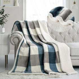 PU MEI Sherpa fleece throw blanket in gray and soft blue drapes over a sofa for warmth.