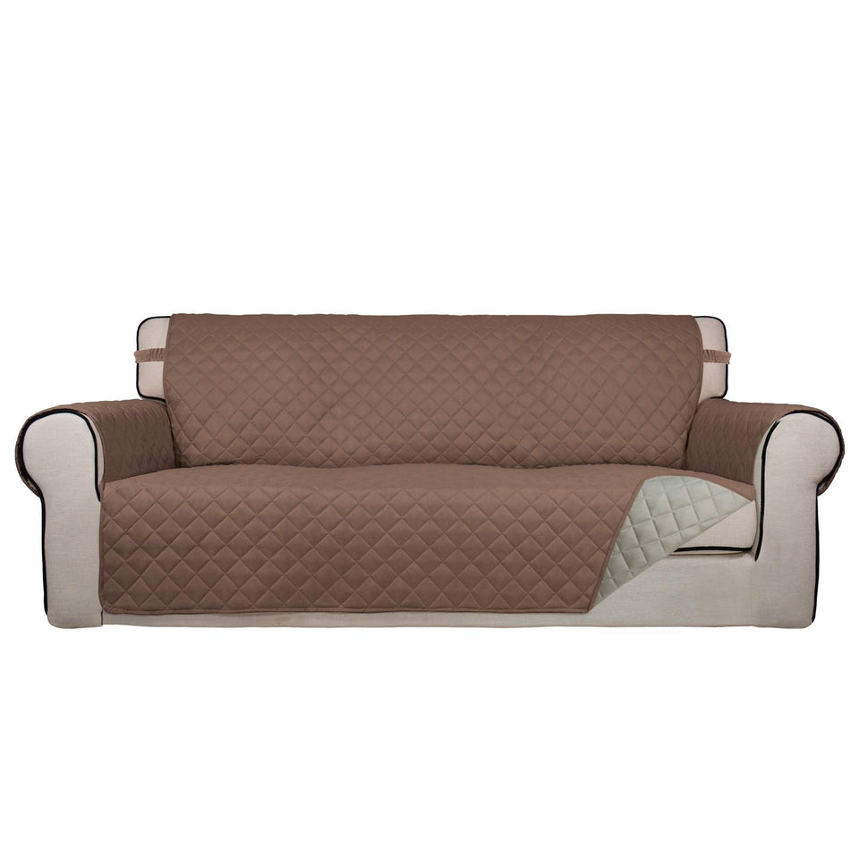 PureFit reversible quilted sofa cover in brown draped over a sofa for protection.