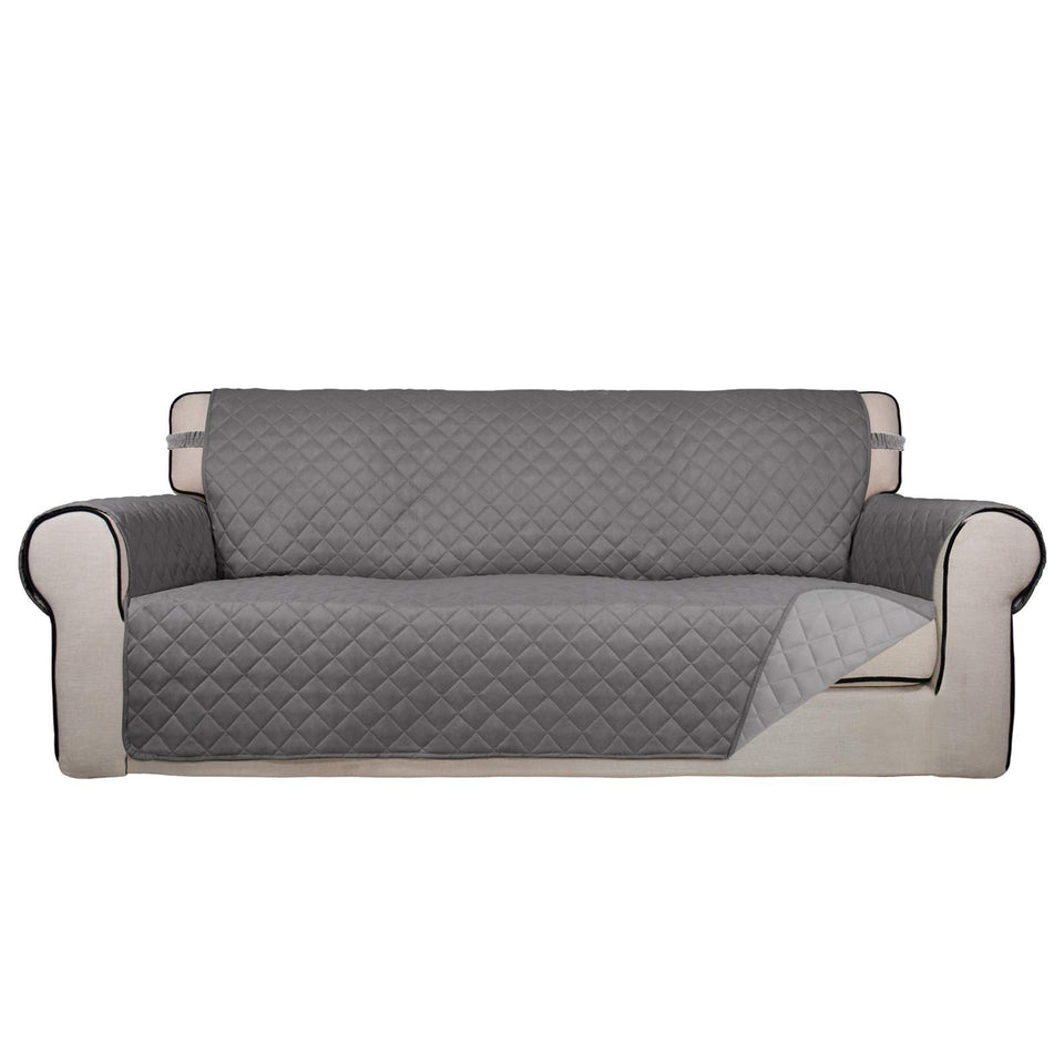 PureFit reversible quilted sofa cover in gray on a sofa refreshes the look and protects it