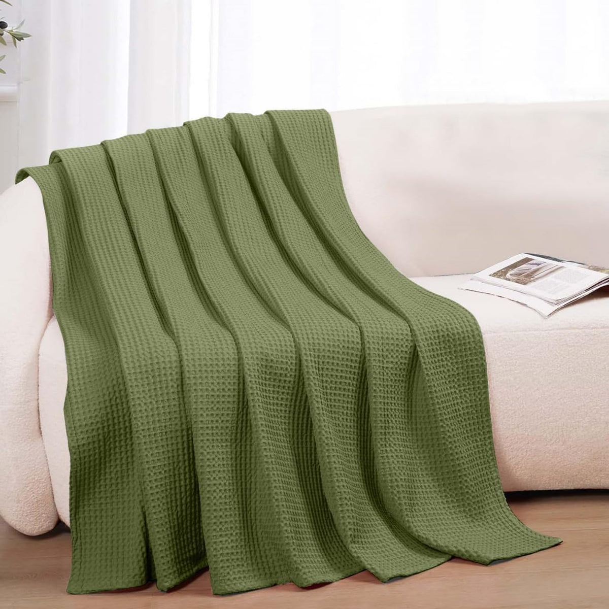 QUBA LINEN blanket laid on a bed in olive green color