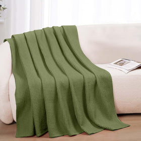 QUBA LINEN blanket laid on a bed in olive green color