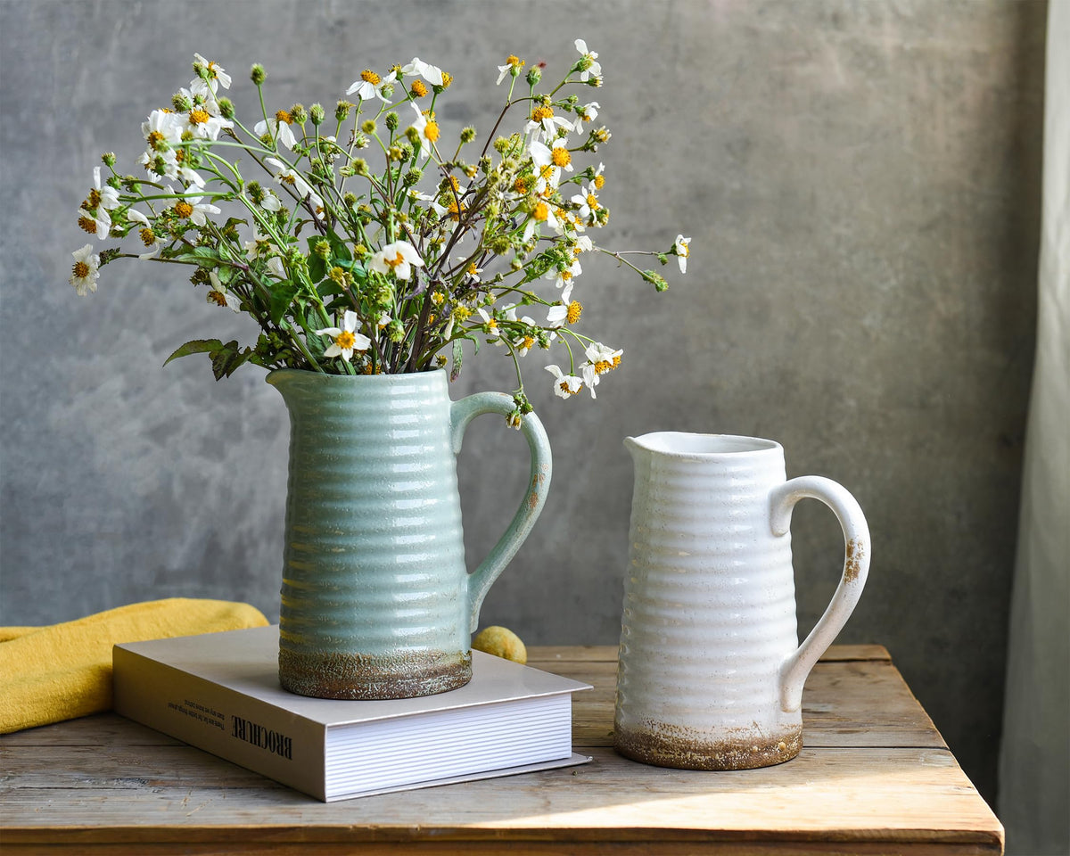 Quoowiit green distressed vase displayed with fresh or dried florals.