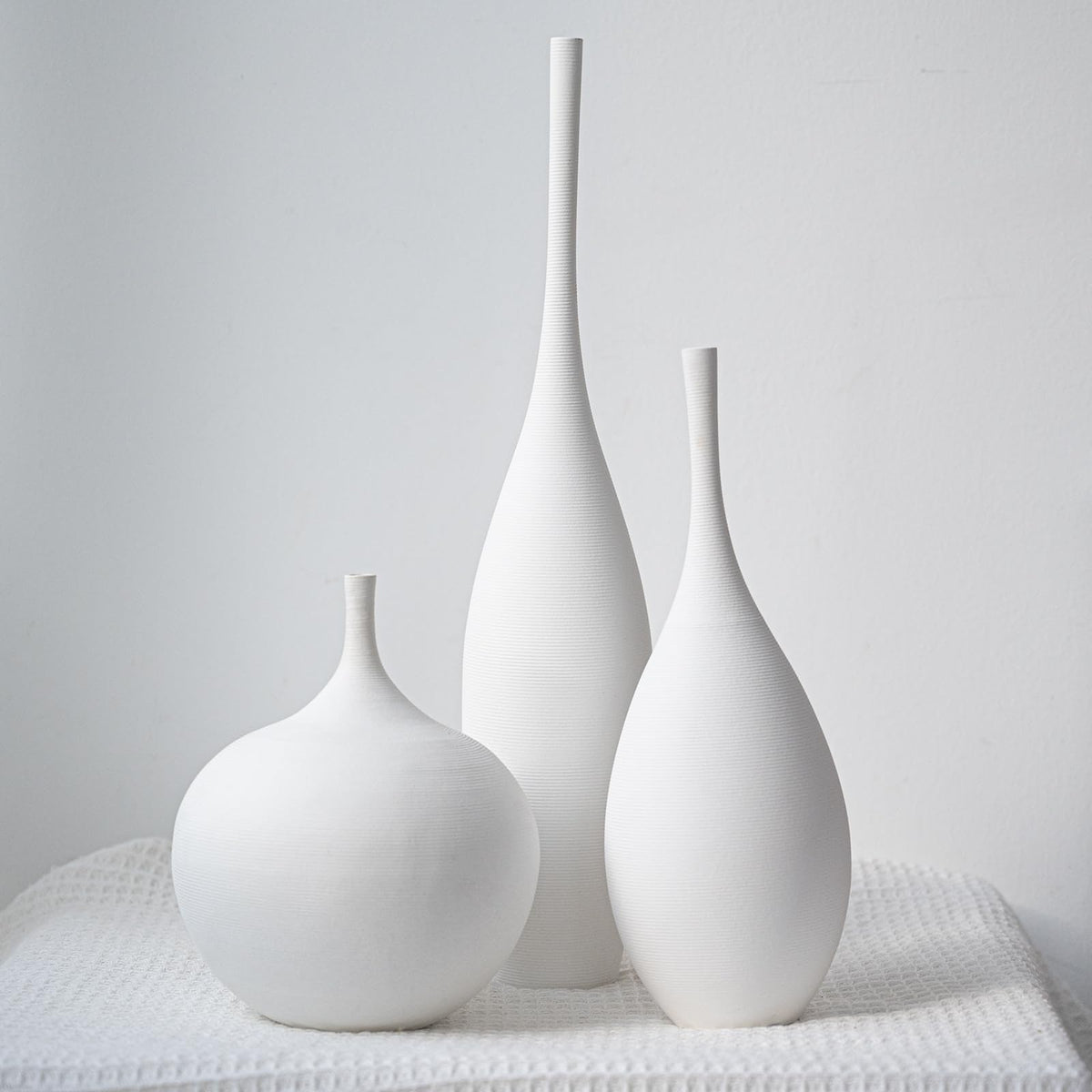 Relexome white ceramic vase trio on desktop adds subtle elegance