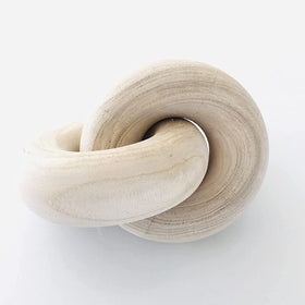 Rool wood knot decor with chain-link design on a beige mantel showing organic texture