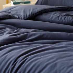 ROSGONIA navy blue comforter on bed demonstrates lightweight warmth.