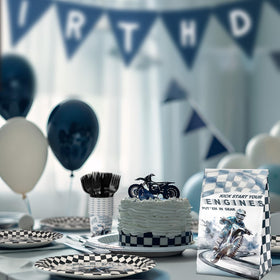 SamPartyShop dirt bike party setup showing coordinated plates, napkins, and forks