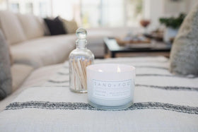 Candle enhances living room ambience with coastal-inspired charm.