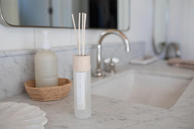 Sand + Fog Ocean Mist diffuser with wood reeds enhancing ambient scent in living spaces